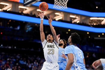 Mar 13, 2025; Charlotte, NC, USA; Wake Forest Demon Deacons guard Hunter Sallis (23) goes to the basket chased by North Carolina Tar Heels guard RJ Davis (4) during the second half at Spectrum Center. Mandatory Credit: Jim Dedmon-Imagn Images