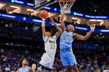 Mar 13, 2025; Charlotte, NC, USA; North Carolina Tar Heels forward Ven-Allen Lubin (22) blocks a shot by Wake Forest Demon Deacons guard Hunter Sallis (23) during the second half at Spectrum Center. Mandatory Credit: Jim Dedmon-Imagn Images