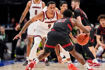 Mar 13, 2025; Charlotte, NC, USA; Louisville Cardinals guard Cole Sherman (4) on defense against Stanford Cardinal guard Jaylen Blakes (21) during the second half at Spectrum Center. Mandatory Credit: Jim Dedmon-Imagn Images