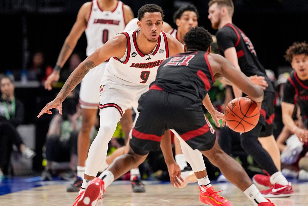 Mar 13, 2025; Charlotte, NC, USA; Louisville Cardinals guard Cole Sherman (4) on defense against Stanford Cardinal guard Jaylen Blakes (21) during the second half at Spectrum Center. Mandatory Credit: Jim Dedmon-Imagn Images