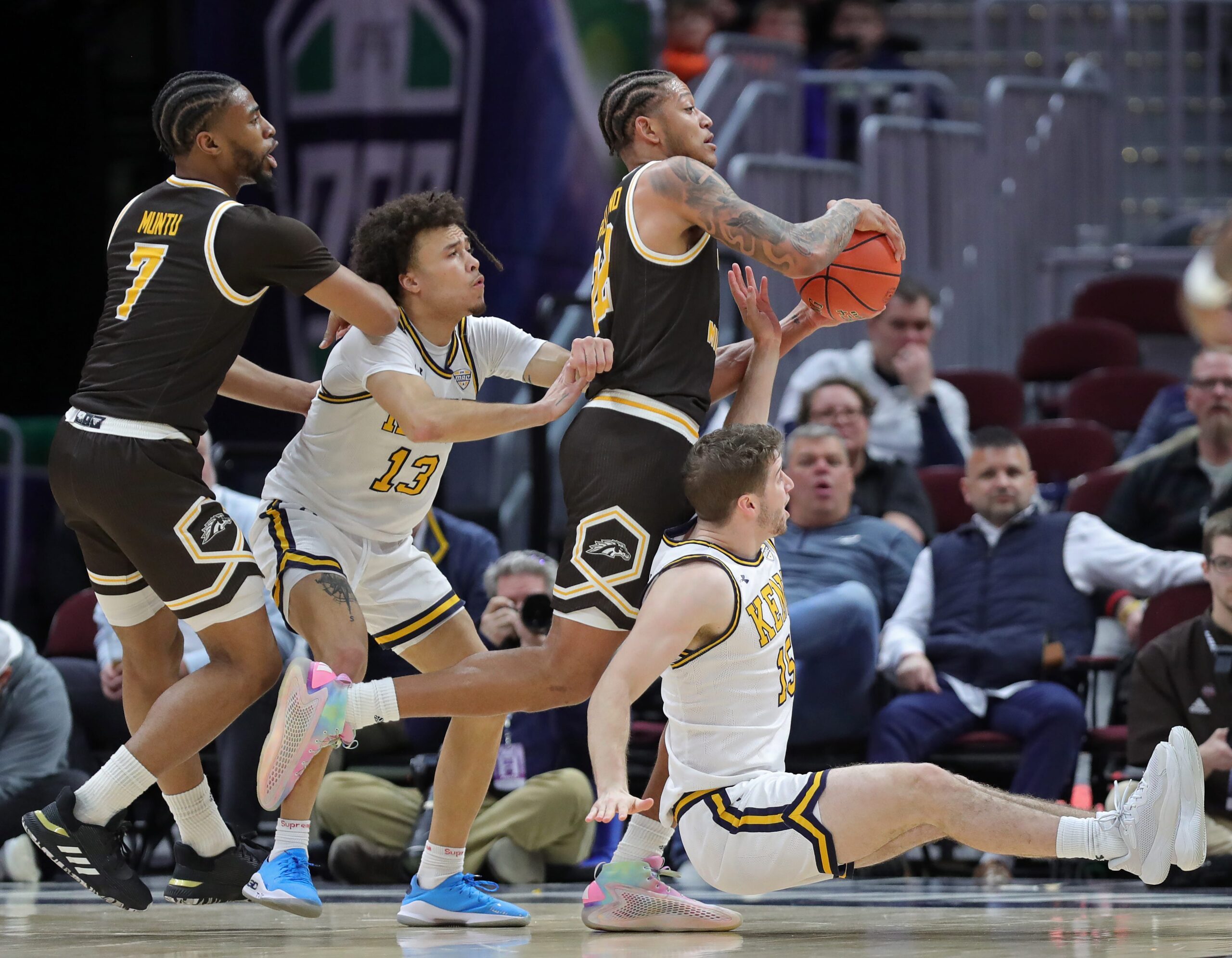 Western Michigan Broncos guard Markhi Strickland (22) controls the ball between Kent State Golden Flashes guard Jalen Sullinger (13) and guard Mike Bekelja (15) during the first half of an NCAA college basketball game in the quarterfinals of the Mid-American Conference Tournament at Rocket Arena on Thursday, March 13, 2025, in Cleveland, Ohio.