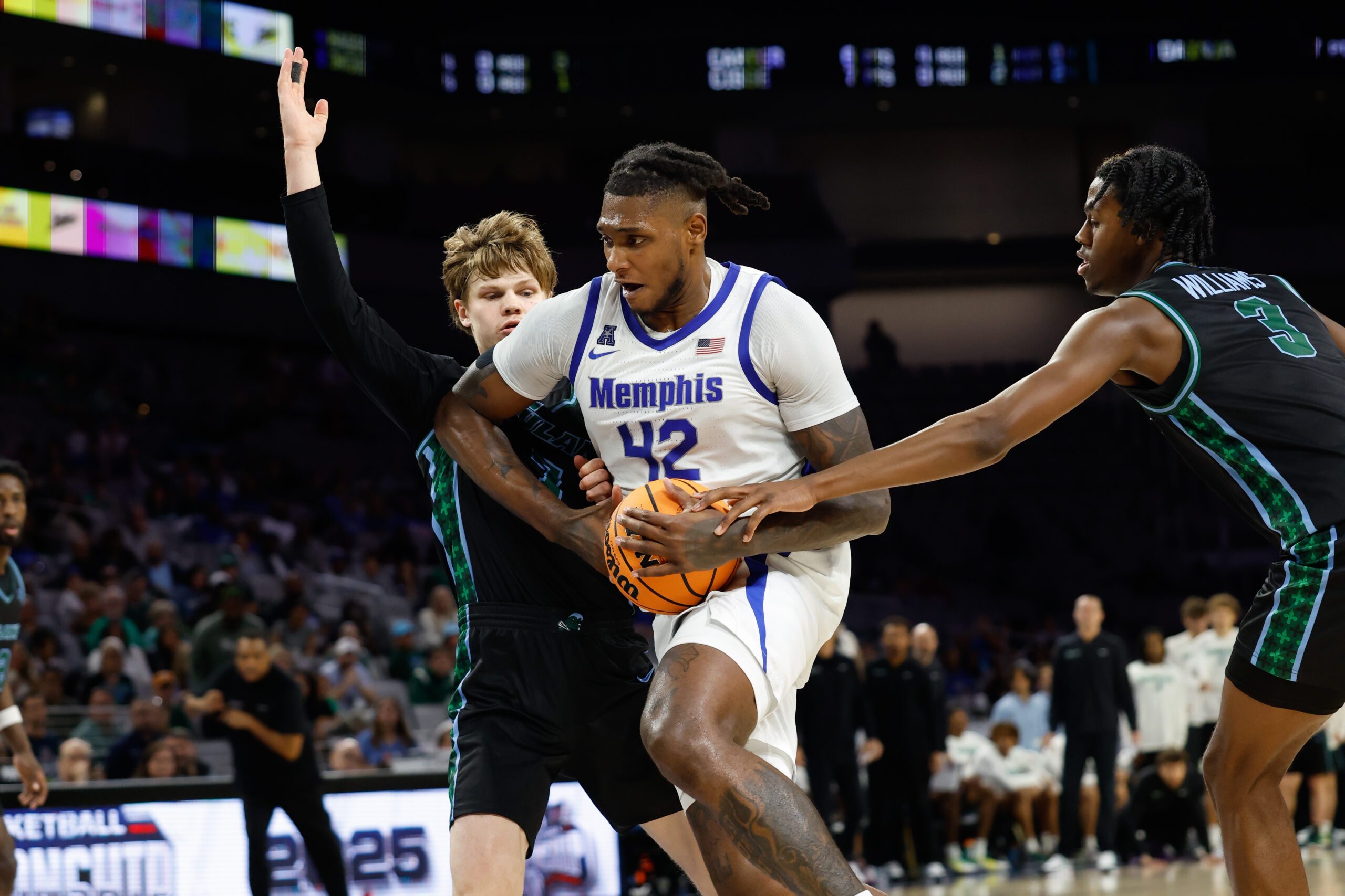 Mar 15, 2025; Fort Worth, TX, USA; Memphis Tigers forward Dain Dainja (42) drives to the basket between Tulane Green Wave guard Rowan Brumbaugh (7) and guard Kam Williams (3) during the second half at Dickies Arena. Mandatory Credit: Chris Jones-Imagn Images