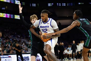 Mar 15, 2025; Fort Worth, TX, USA; Memphis Tigers forward Dain Dainja (42) drives to the basket between Tulane Green Wave guard Rowan Brumbaugh (7) and guard Kam Williams (3) during the second half at Dickies Arena. Mandatory Credit: Chris Jones-Imagn Images