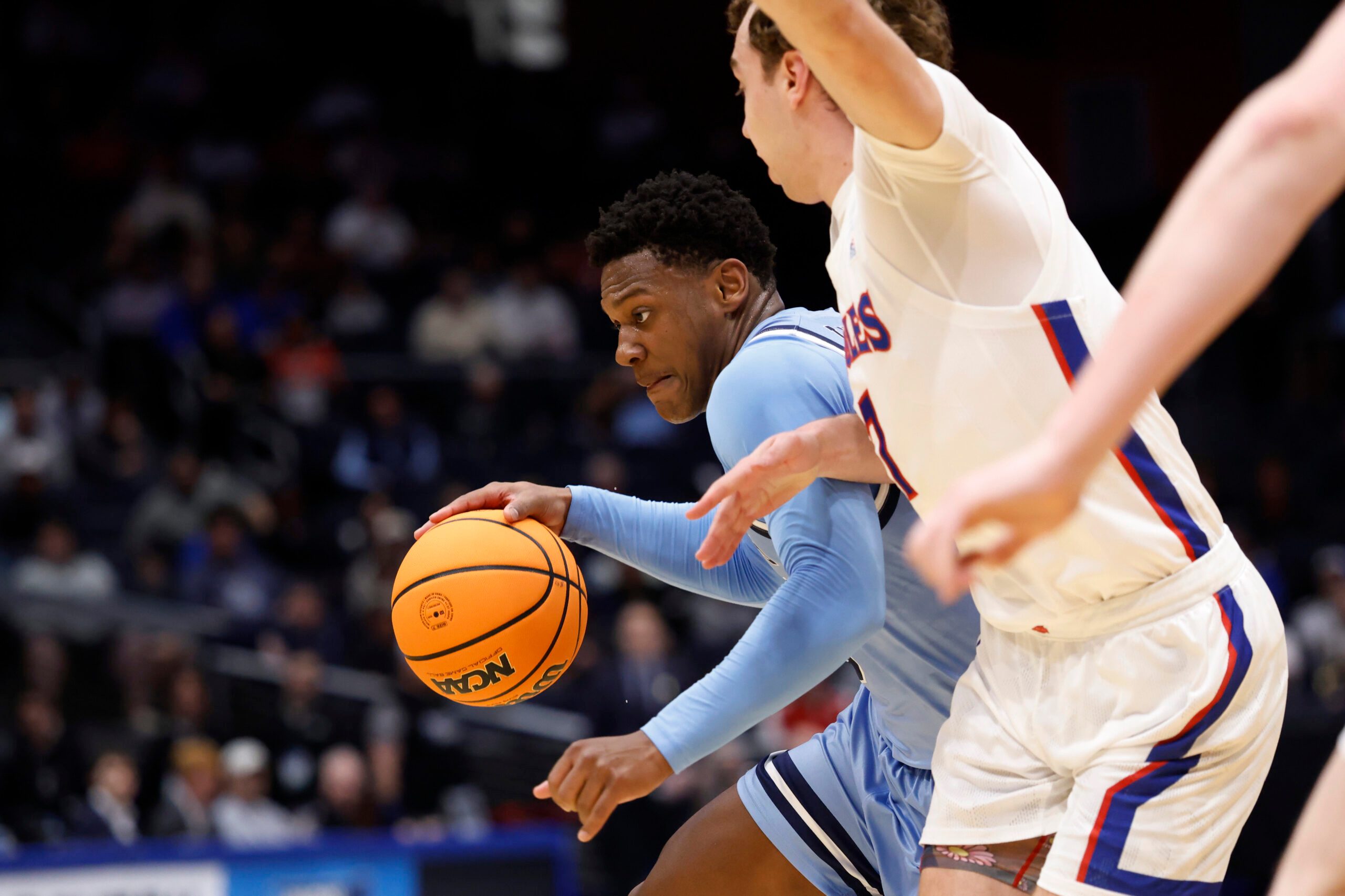Mar 19, 2025; Dayton, OH, USA; Mount St. Mary's Mountaineers guard Xavier Lipscomb (45) plays the ball defended by American University Eagles guard Wyatt Nausadis (7) in the first half at UD Arena. Mandatory Credit: Rick Osentoski-Imagn Images