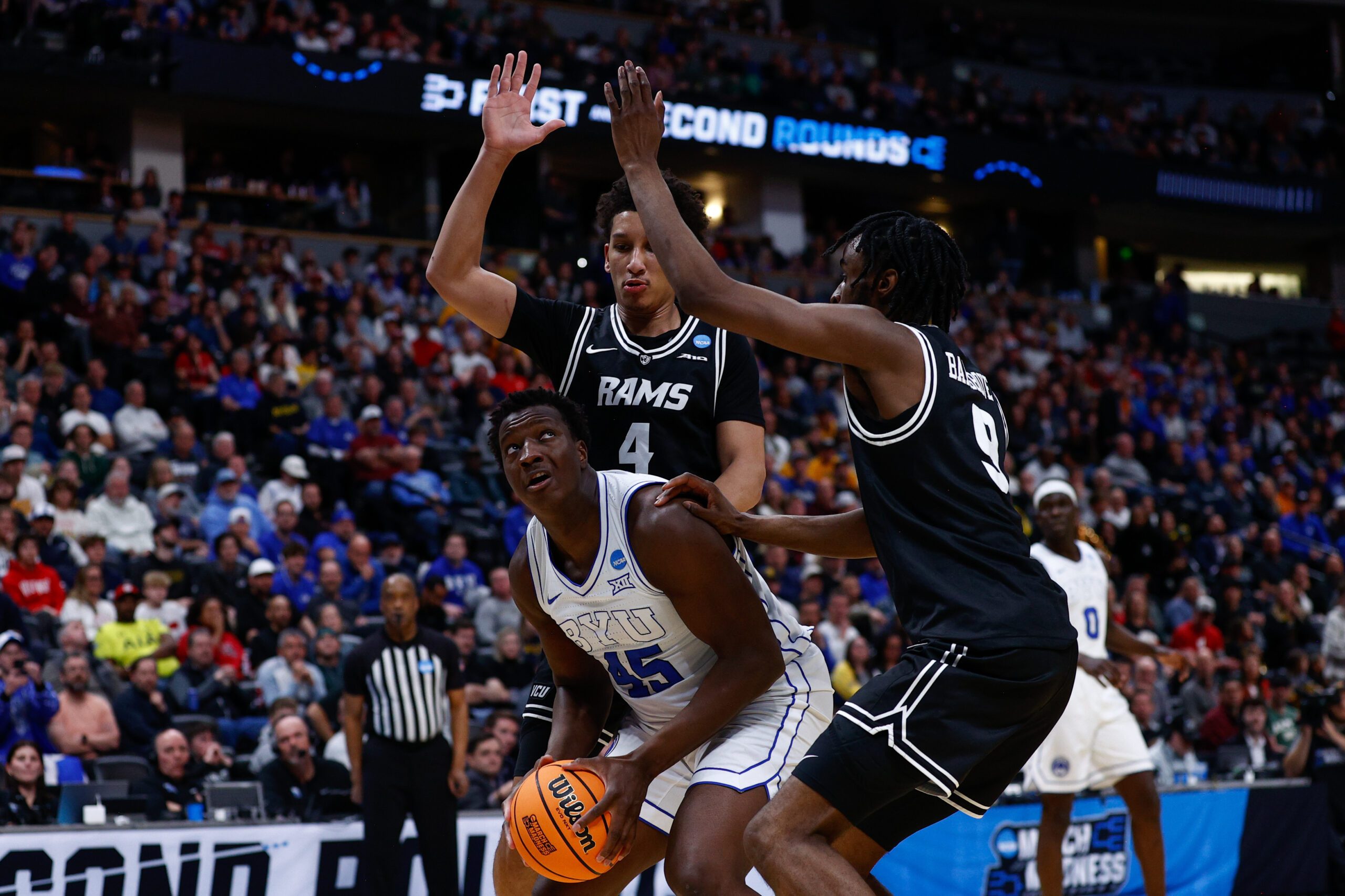 Mar 20, 2025; Denver, CO, USA; VCU Rams forward Jack Clark (4) and forward Luke Bamgboye (9) defend against Brigham Young Cougars center Fousseyni Traore (45) during the second half in the first round of the NCAA Tournament at Ball Arena. Mandatory Credit: Isaiah J. Downing-Imagn Images