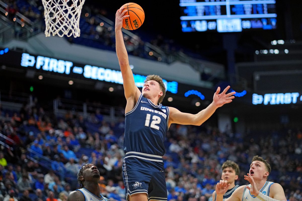 Mar 20, 2025; Lexington, KY, USA; Utah State Aggies guard Mason Falslev (12) shoots the ball during the second half against the UCLA Bruins in the first round of the NCAA Tournament at Rupp Arena. Mandatory Credit: Aaron Doster-Imagn Images