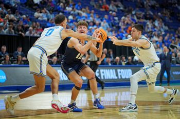 Mar 20, 2025; Lexington, KY, USA;  Utah State Aggies guard Mason Falslev (12) drives to the basket against UCLA Bruins guard Kobe Johnson (0) during the second half in the first round of the NCAA Tournament at Rupp Arena. Mandatory Credit: Aaron Doster-Imagn Images