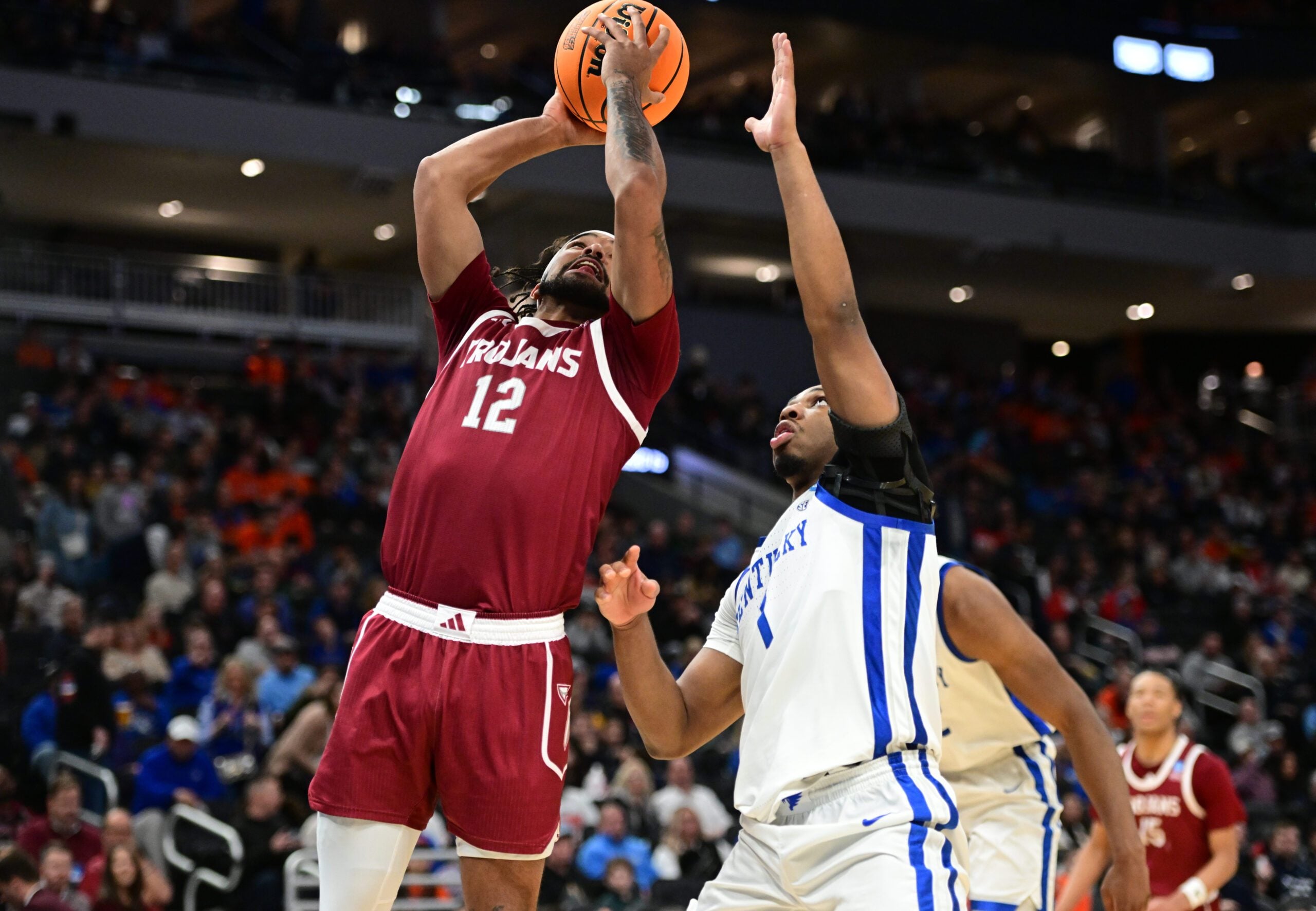 Mar 21, 2025; Milwaukee, WI, USA; Troy Trojans guard Tayton Conerway (12) drives to the hoop past Kentucky Wildcats guard Lamont Butler (1) during the second half at Fiserv Forum. Mandatory Credit: Benny Sieu-Imagn Images