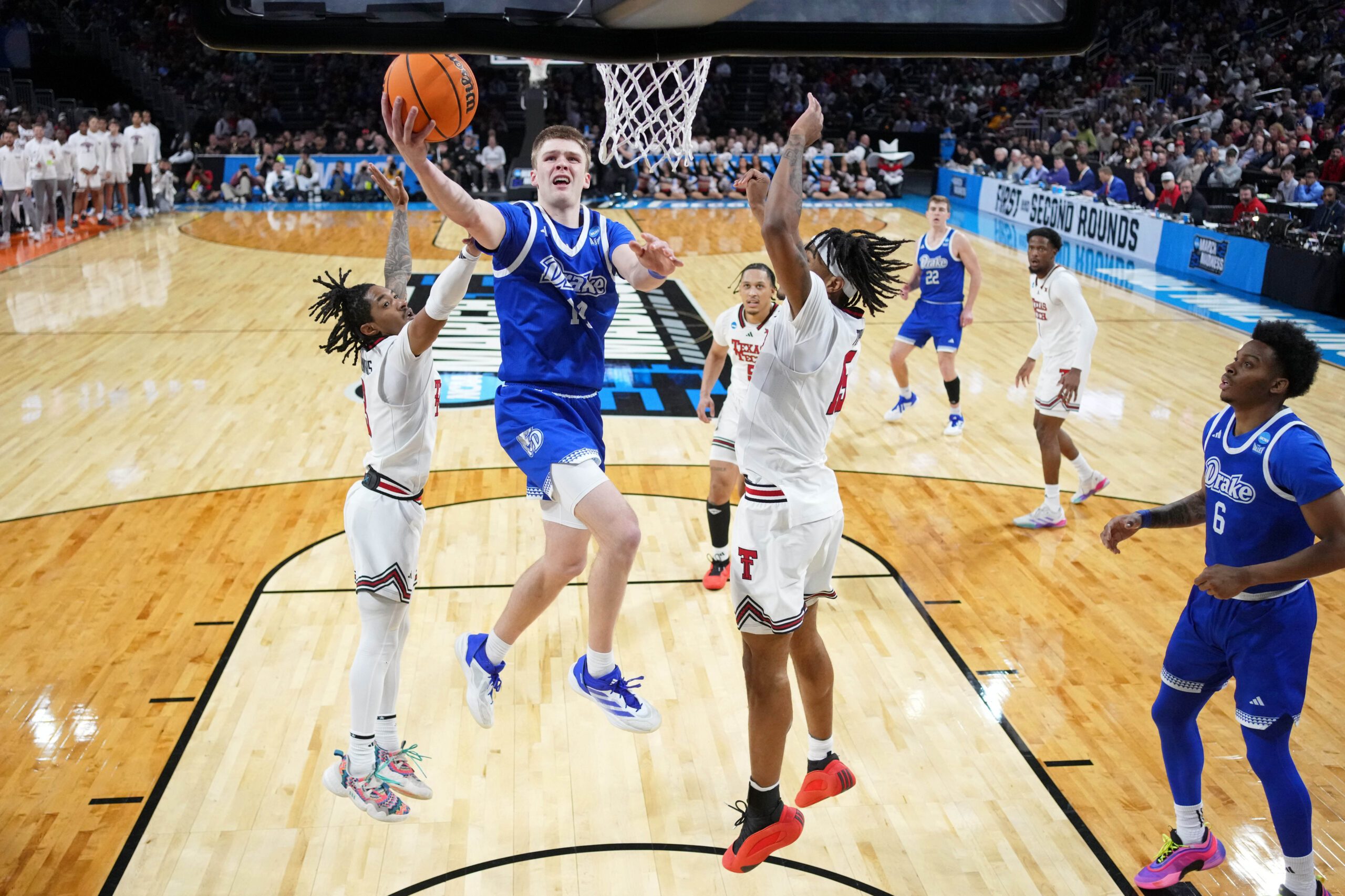 Mar 22, 2025; Wichita, KS, USA; Drake Bulldogs guard Bennett Stirtz (14) shoots the ball against Texas Tech Red Raiders guard Elijah Hawkins (3) and forward JT Toppin (15) during the second half at Intrust Bank Arena. Mandatory Credit: Kirby Lee-Imagn Images
