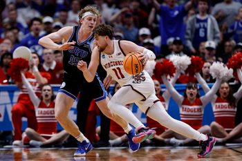 Mar 22, 2025; Denver, CO, USA; Wisconsin Badgers guard Max Klesmit (11) dribbles the ball past Brigham Young Cougars forward Richie Saunders (15) during the second half in the second round of the NCAA Tournament  at Ball Arena. Mandatory Credit: Isaiah J. Downing-Imagn Images