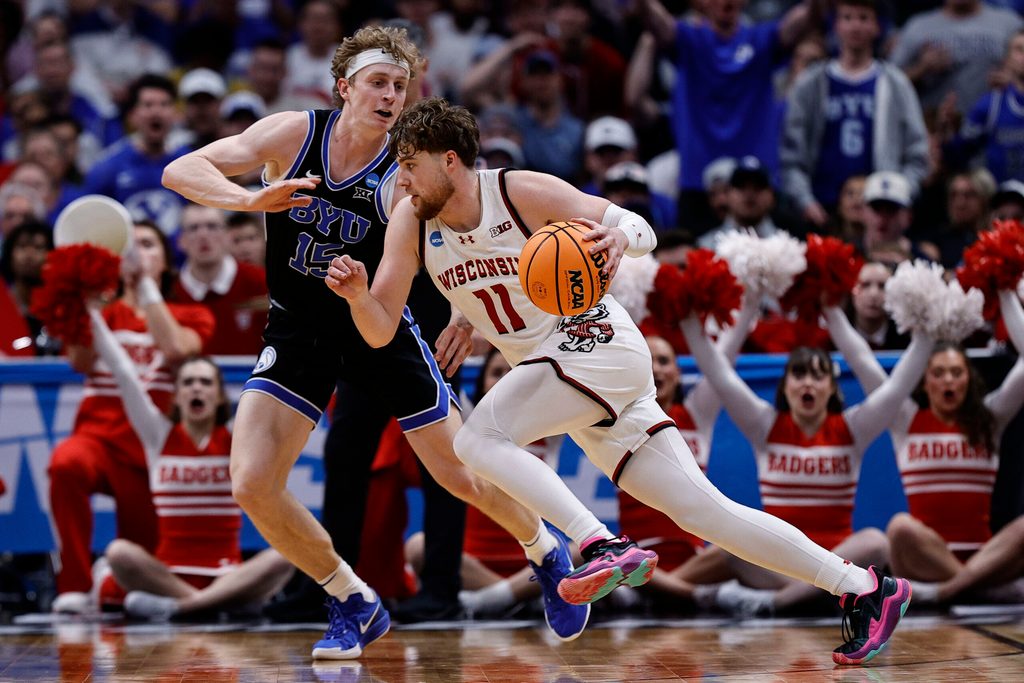 Mar 22, 2025; Denver, CO, USA; Wisconsin Badgers guard Max Klesmit (11) dribbles the ball past Brigham Young Cougars forward Richie Saunders (15) during the second half in the second round of the NCAA Tournament at Ball Arena. Mandatory Credit: Isaiah J. Downing-Imagn Images
