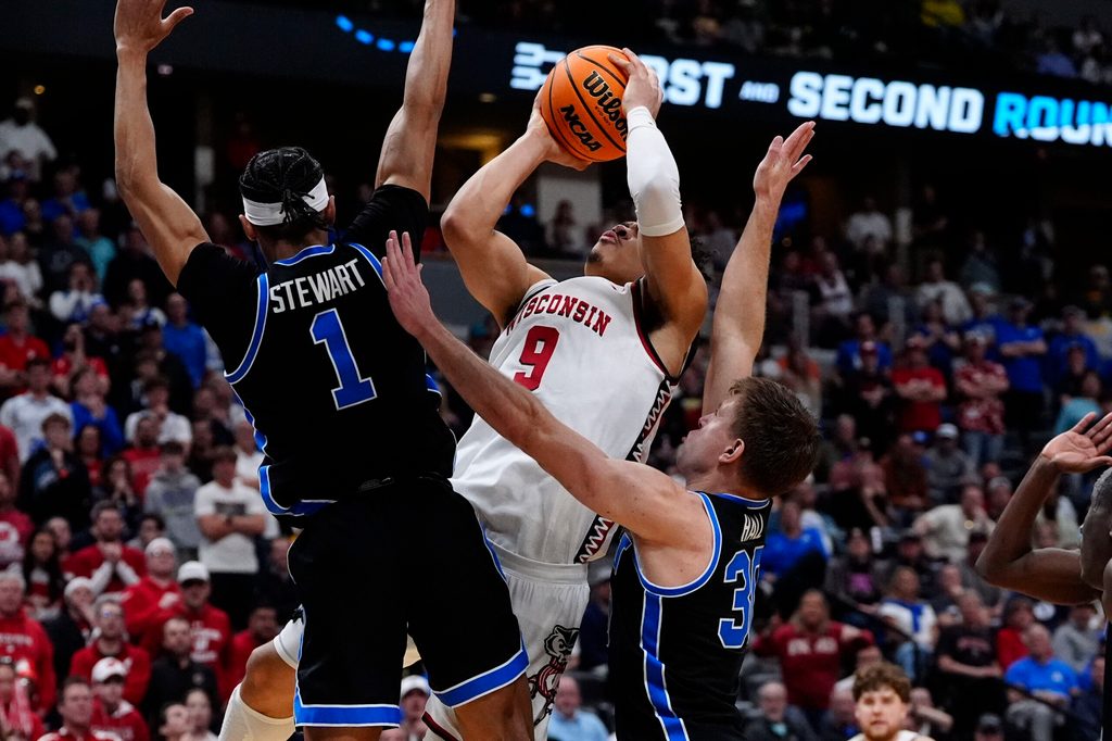 Mar 22, 2025; Denver, CO, USA; Wisconsin Badgers guard John Tonje (9) shoots the ball over Brigham Young Cougars guard Trey Stewart (1) during the second half in the second round of the NCAA Tournament at Ball Arena. Mandatory Credit: Ron Chenoy-Imagn Images