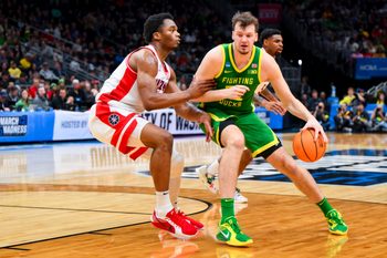 Mar 23, 2025; Seattle, WA, USA;  Oregon Ducks center Nate Bittle (32) dribbles the ball against Arizona Wildcats forward Tobe Awaka (30) in the first half at Climate Pledge Arena. Mandatory Credit: Steven Bisig-Imagn Images
