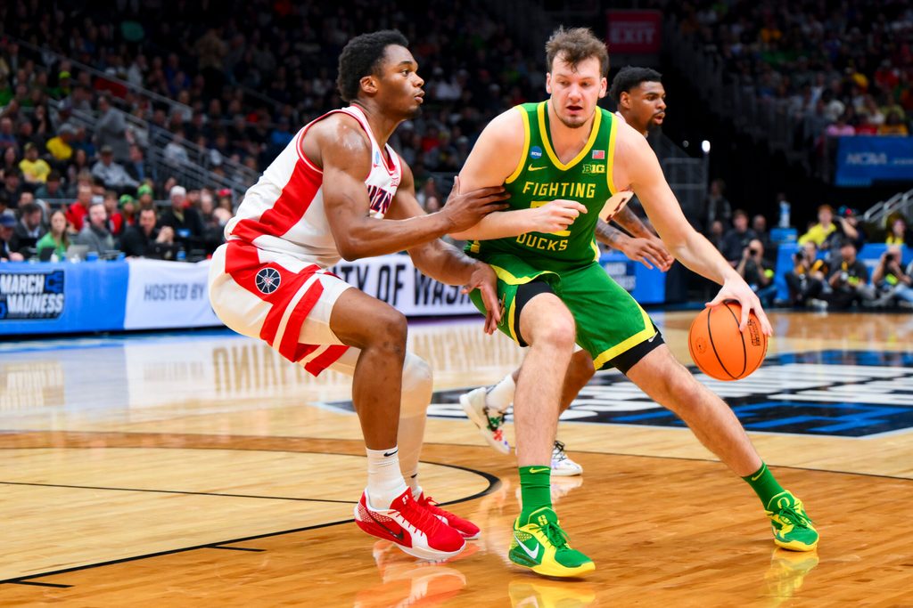 Mar 23, 2025; Seattle, WA, USA; Oregon Ducks center Nate Bittle (32) dribbles the ball against Arizona Wildcats forward Tobe Awaka (30) in the first half at Climate Pledge Arena. Mandatory Credit: Steven Bisig-Imagn Images
