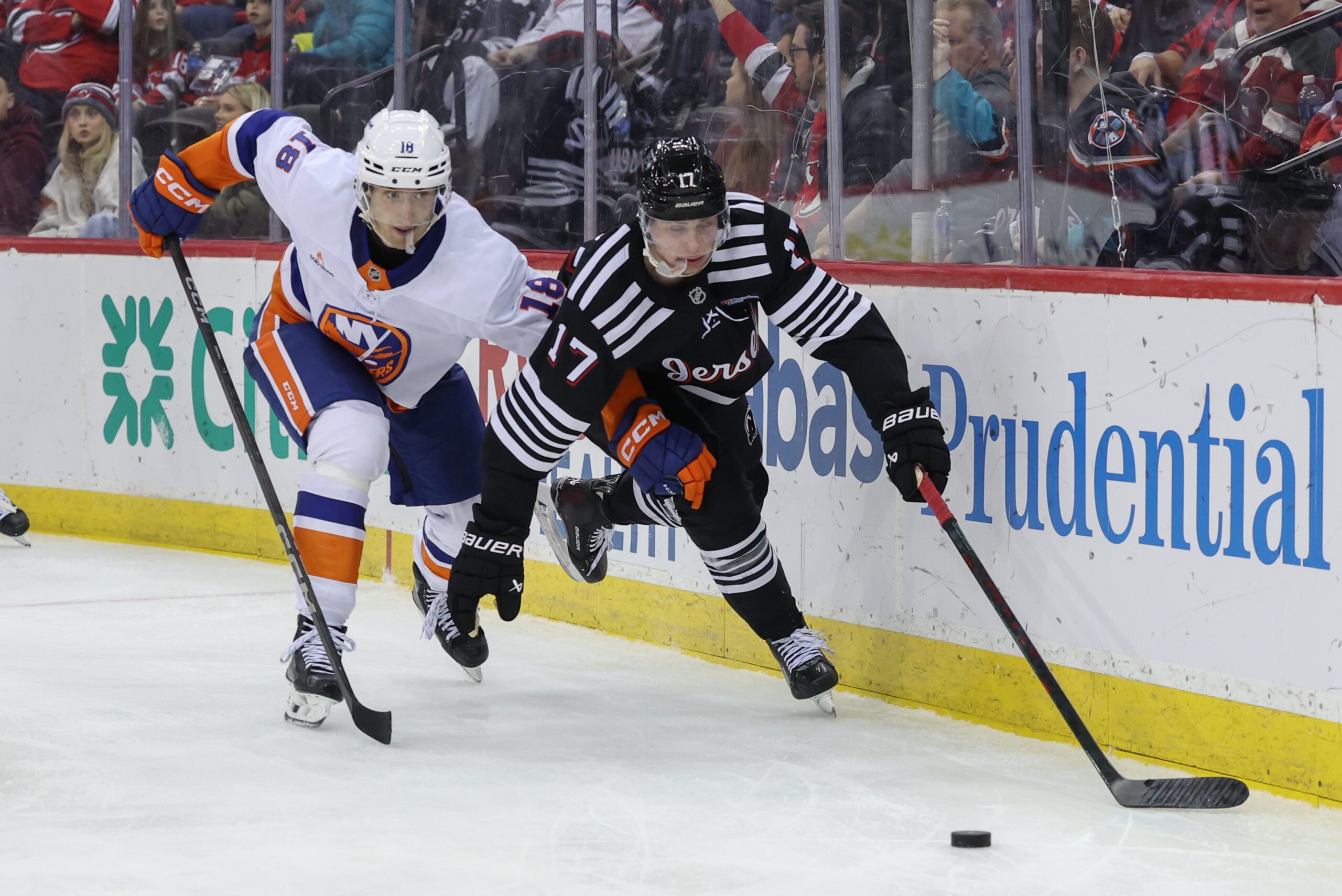 Apr 13, 2025; Newark, New Jersey, USA; New Jersey Devils defenseman Simon Nemec (17) and New York Islanders left wing Pierre Engvall (18) battle for the puck during the third period at Prudential Center. Mandatory Credit: Ed Mulholland-Imagn Images