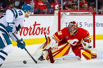 Apr 13, 2025; Calgary, Alberta, CAN; Calgary Flames goaltender Dustin Wolf (32) makes a save against San Jose Sharks left wing William Eklund (72) during the third period at Scotiabank Saddledome. Mandatory Credit: Sergei Belski-Imagn Images