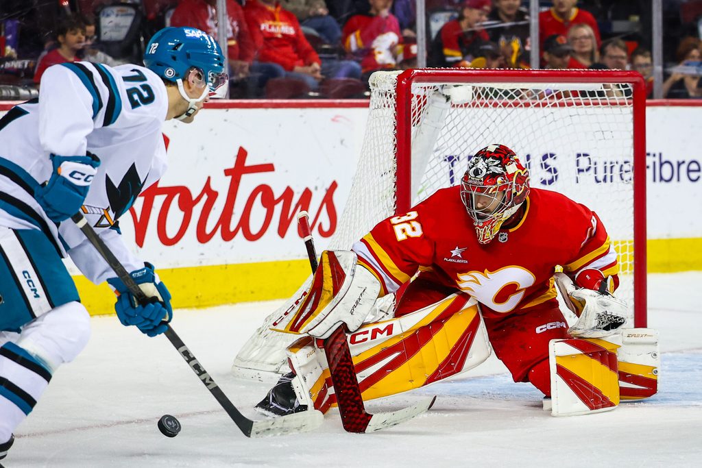 Apr 13, 2025; Calgary, Alberta, CAN; Calgary Flames goaltender Dustin Wolf (32) makes a save against San Jose Sharks left wing William Eklund (72) during the third period at Scotiabank Saddledome. Mandatory Credit: Sergei Belski-Imagn Images