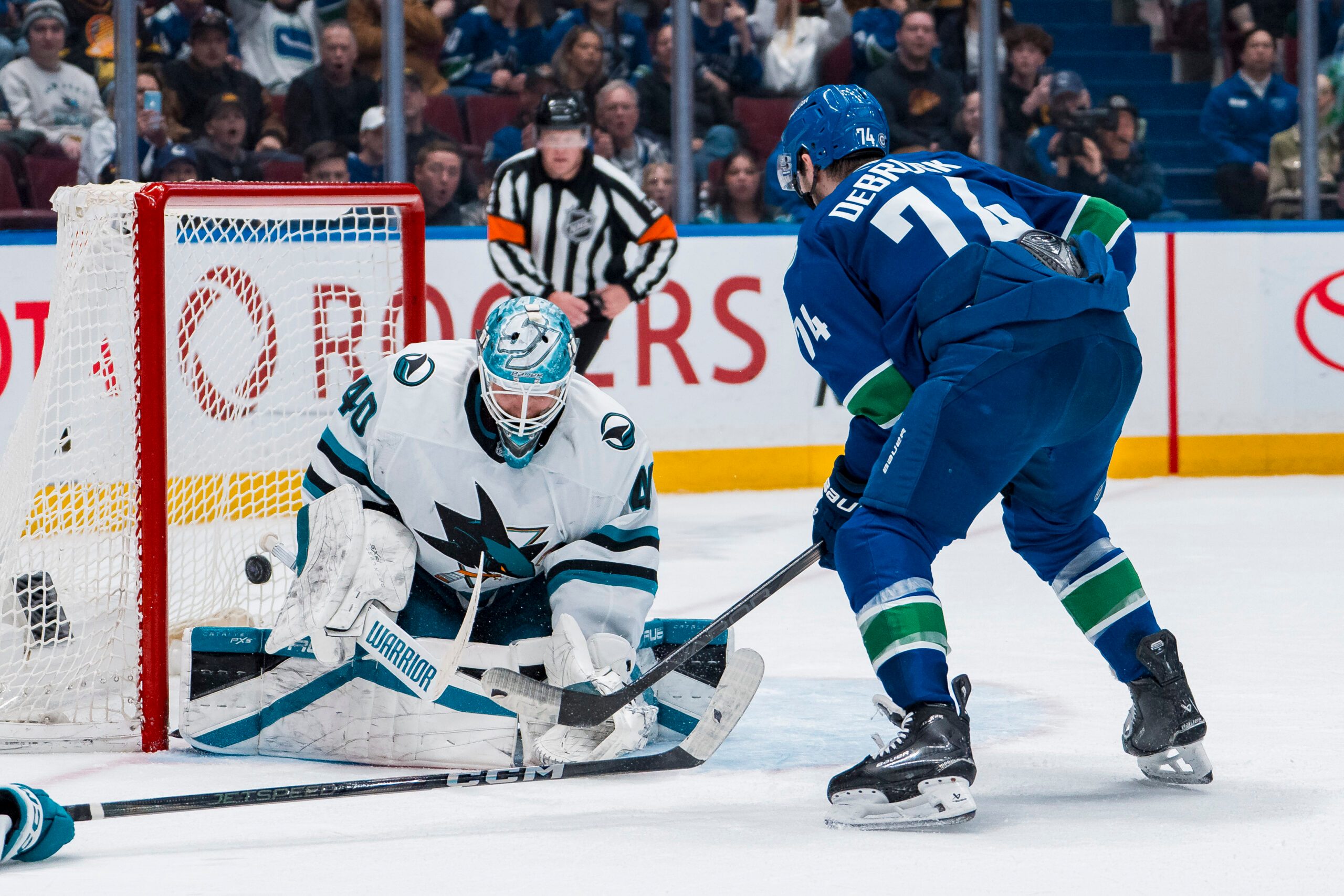 Apr 14, 2025; Vancouver, British Columbia, CAN; Vancouver Canucks forward Jake DeBrusk (74) scores on San Jose Sharks goalie Alexandar Georgiev (40) in overtime at Rogers Arena. Mandatory Credit: Bob Frid-Imagn Images
