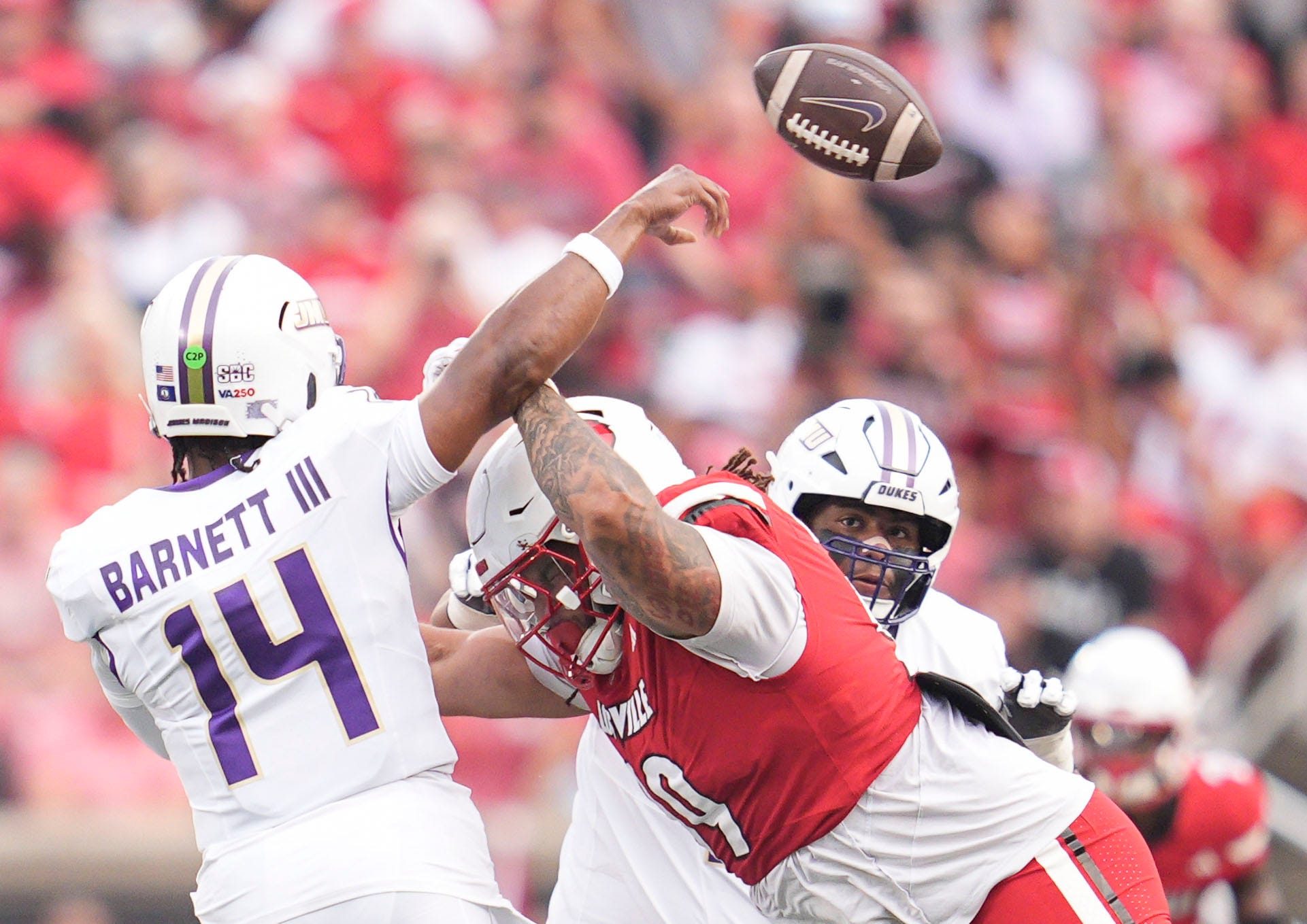 Louisville Cardinals defensive lineman Jordan Guerad (99) pressures James Madison Dukes quarterback Alonza Barnett III (14) in the first half Friday September 5, 2025 at L&N Federal Credit Union Stadium in Louisville, Kentucky.