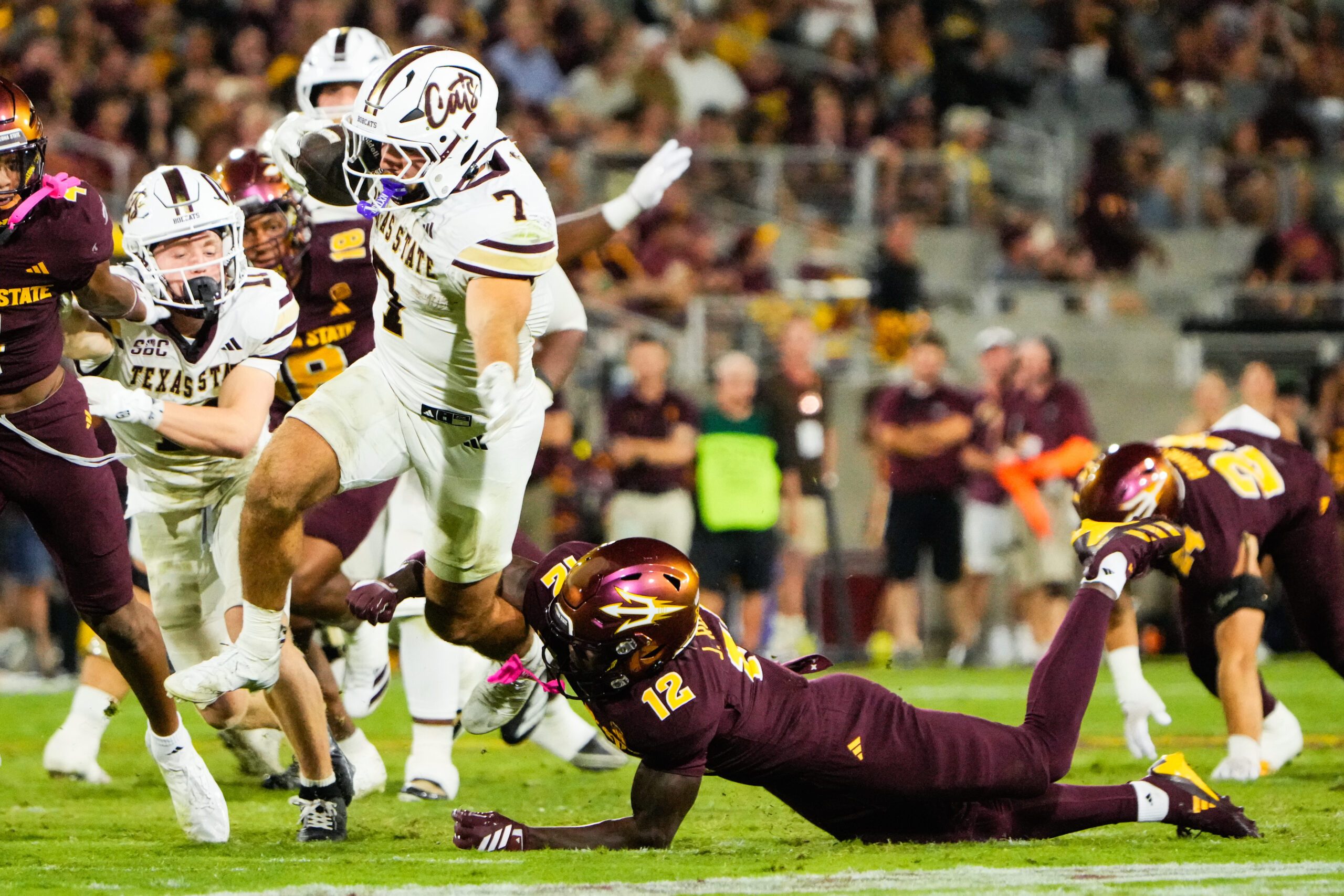 Sep 13, 2025; Tempe, Arizona, USA; Texas State Bobcats running back Lincoln Pare (7) avoids a tackle by Arizona State Sun Devils defensive back Javan Robinson (12) in the third quarter of the game between Arizona State Sun Devils and Texas State Bobcats. Mandatory Credit: Arianna Grainey-Imagn Images