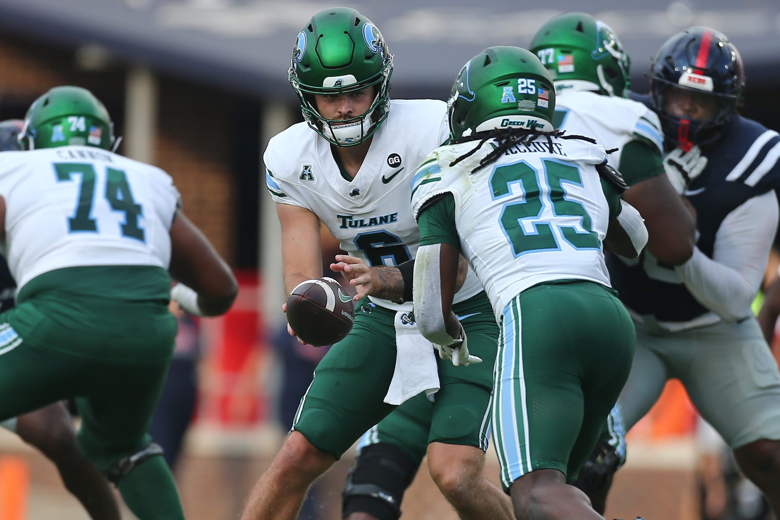 Sep 20, 2025; Oxford, Mississippi, USA; Tulane Green Wave quarterback Brendan Sullivan (6) hands the ball off to running back Jamauri McClure (25) during the fourth quarter against the Mississippi Rebels at Vaught-Hemingway Stadium. Mandatory Credit: Petre Thomas-Imagn Images