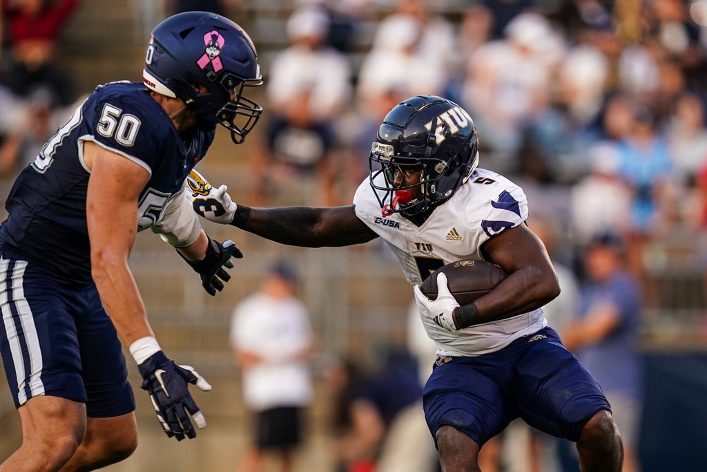 Oct 4, 2025; East Hartford, Connecticut, USA; FIU Panthers running back Kejon Owens (5) runs the ball against UConn Huskies defensive lineman Brandon Kelley (50) in the third quarter at Pratt & Whitney Stadium at Rentschler Field. Mandatory Credit: David Butler II-Imagn Images