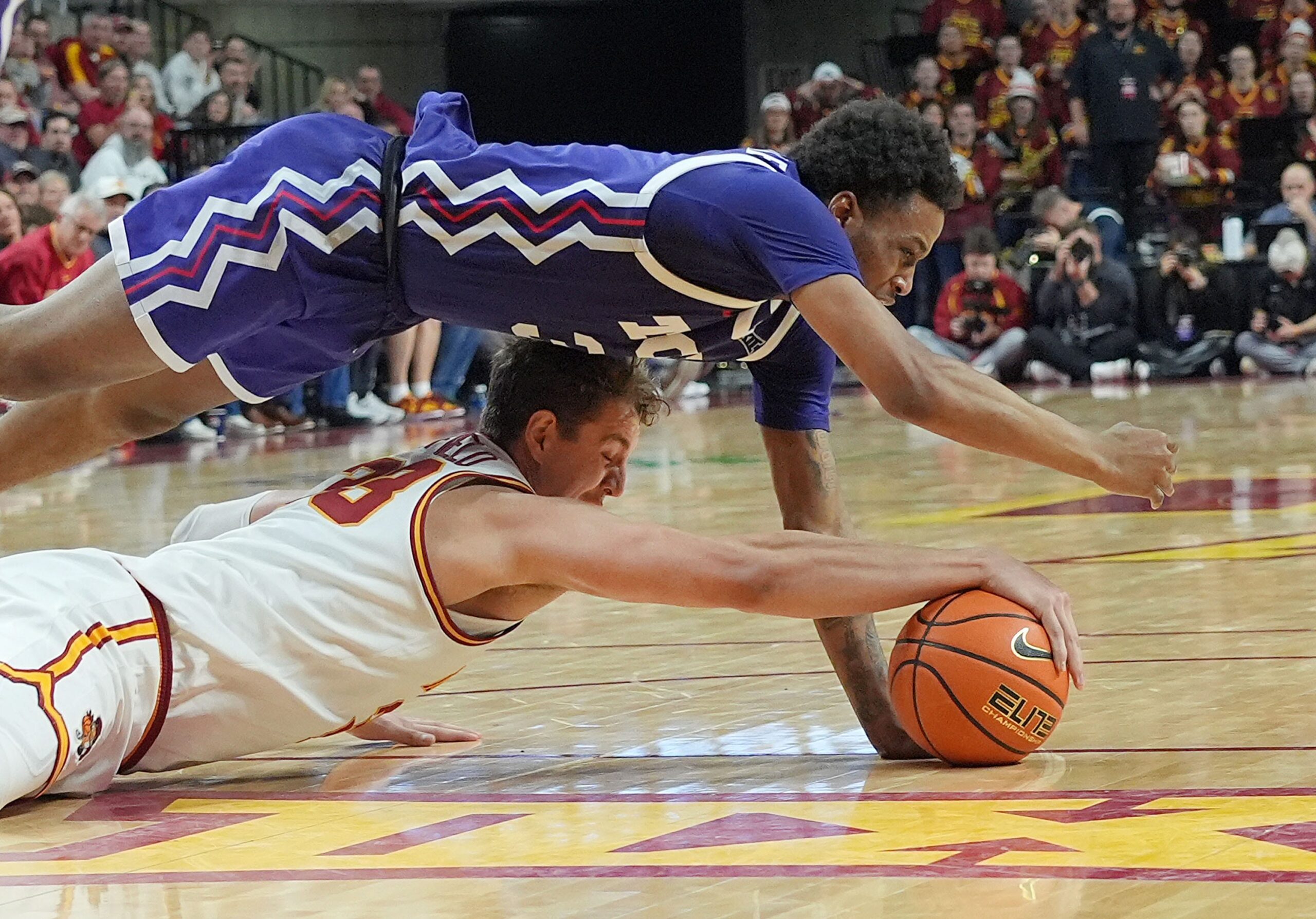 Iowa State Cyclones forward Brandton Chatfield, bottom, and TCU Horned Frogs guard Vasean Allette battle for a loose ball during a Big 12 men’s basketball game at Hilton Coliseum on Feb 8, 2025 in Ames, Iowa.