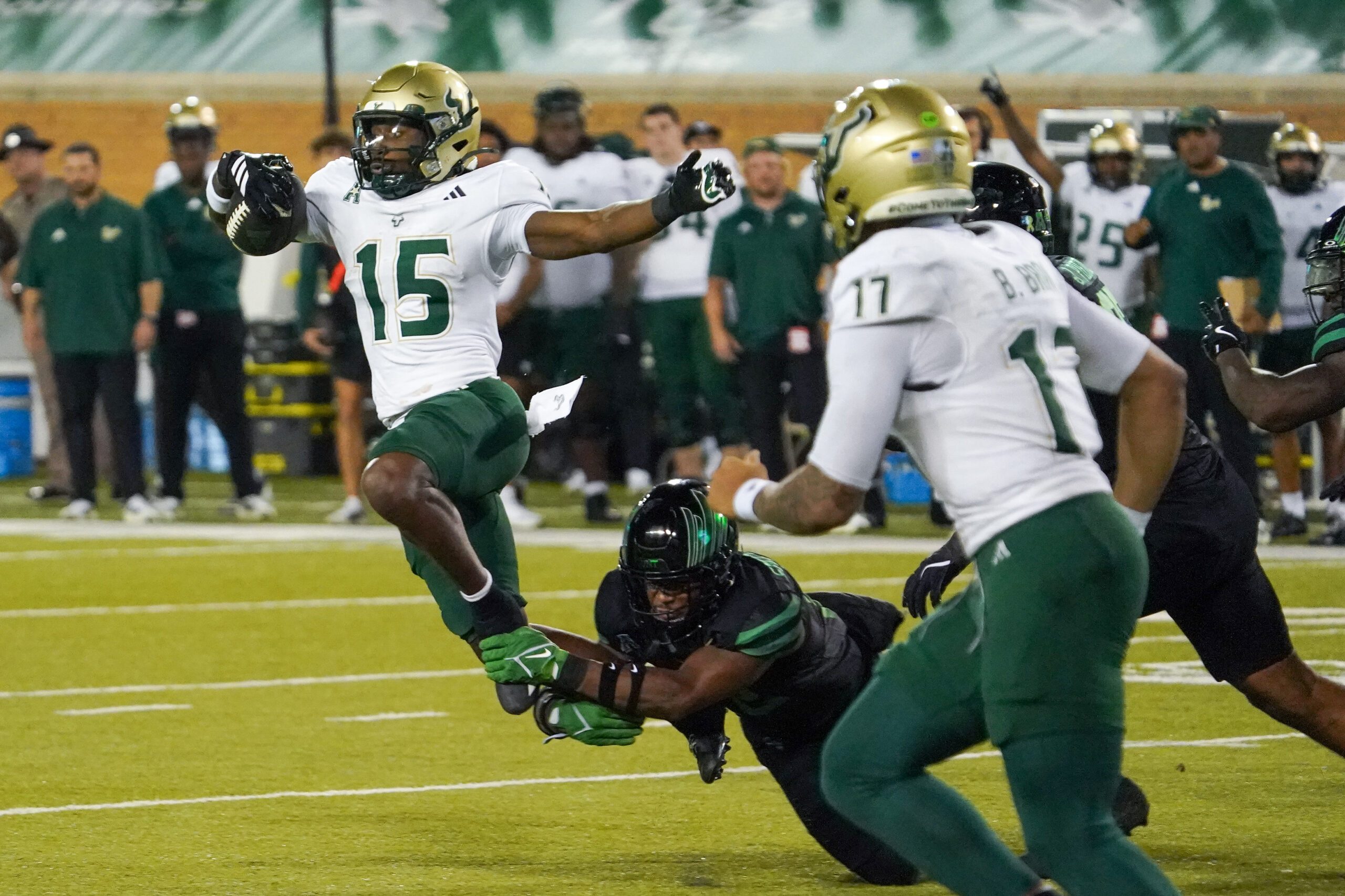Oct 10, 2025; Denton, Texas, USA; South Florida Bulls running back Alvon Isaac (15) is tripped up by North Texas Mean Green safety Patrick Smith-Young (12) during the second half of a game at DATCU Stadium. Mandatory Credit: Raymond Carlin III-Imagn Images