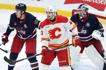 Oct 24, 2025; Winnipeg, Manitoba, CAN; Winnipeg Jets defenseman Logan Stanley (64), Calgary Flames right wing Adam Klapka (43) and Winnipeg Jets goaltender Eric Comrie (1) watch the play in the third period at Canada Life Centre. Mandatory Credit: James Carey Lauder-Imagn Images