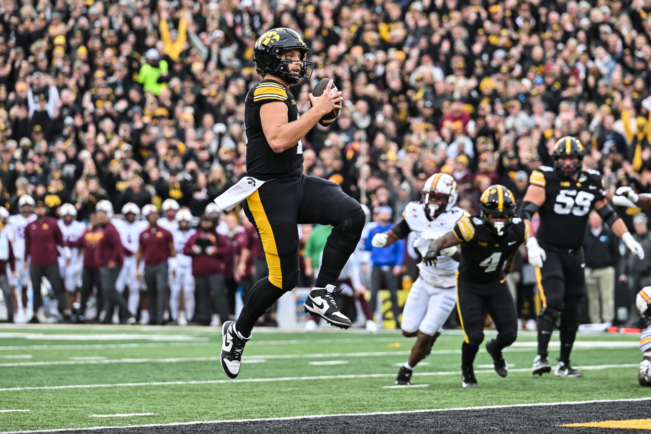 Oct 25, 2025; Iowa City, Iowa, USA; Iowa Hawkeyes quarterback Mark Gronowski (11) runs for a touchdown during the first quarter against the Minnesota Golden Gophers at Kinnick Stadium. Mandatory Credit: Jeffrey Becker-Imagn Images