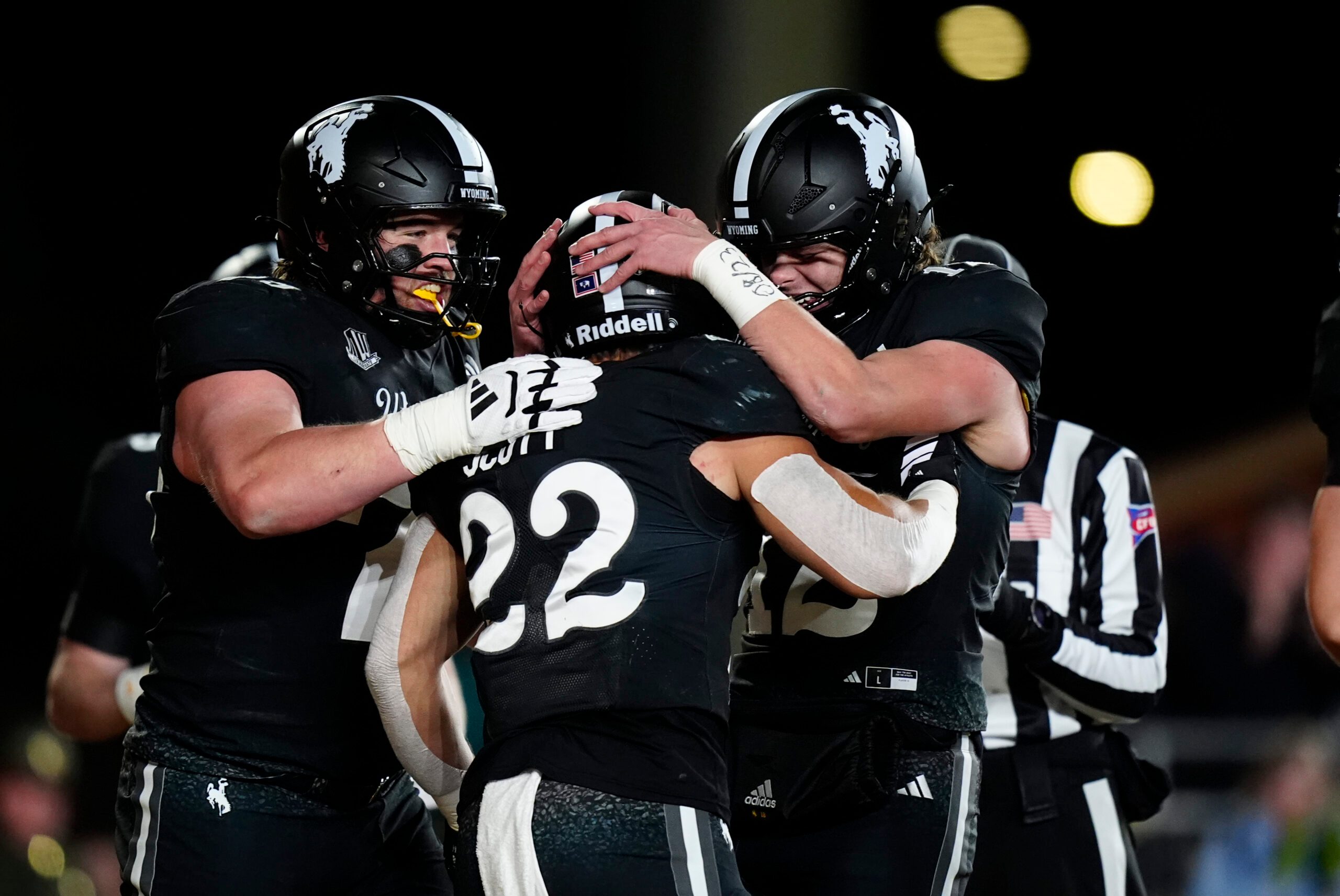 Oct 25, 2025; Laramie, Wyoming, USA; Wyoming Cowboys running back Sam Scott (22) celebrates his touchdown with quarterback Kaden Anderson (12) and offensive guard Wes King (78) in the second half against the Colorado State Rams at Jonah Field at War Memorial Stadium. Mandatory Credit: Ron Chenoy-Imagn Images