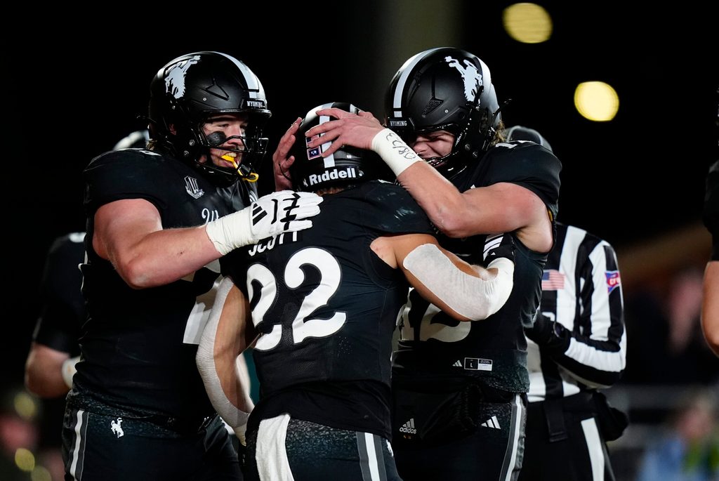 Oct 25, 2025; Laramie, Wyoming, USA; Wyoming Cowboys running back Sam Scott (22) celebrates his touchdown with quarterback Kaden Anderson (12) and offensive guard Wes King (78) in the second half against the Colorado State Rams at Jonah Field at War Memorial Stadium. Mandatory Credit: Ron Chenoy-Imagn Images