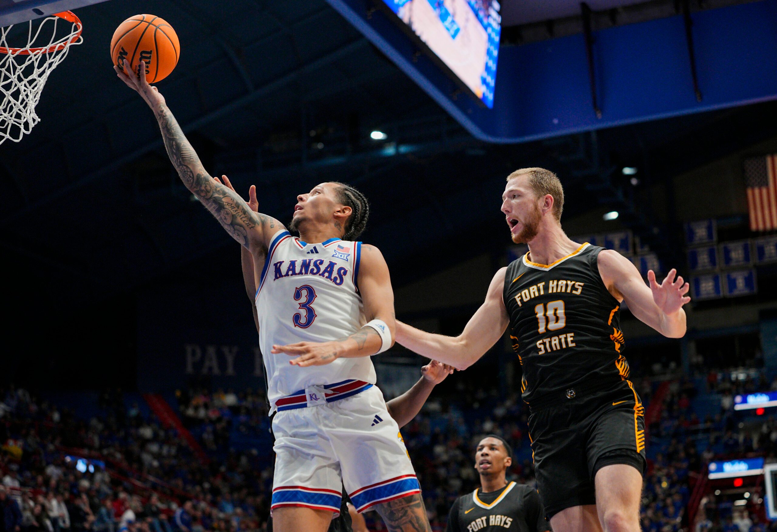 Oct 28, 2025; Lawrence, KS, USA; Kansas Jayhawks guard Tre White (3) shoots against Fort Hays State Tigers guard Blake Danitschek (10) during the second half at Allen Fieldhouse. Mandatory Credit: Jay Biggerstaff-Imagn Images