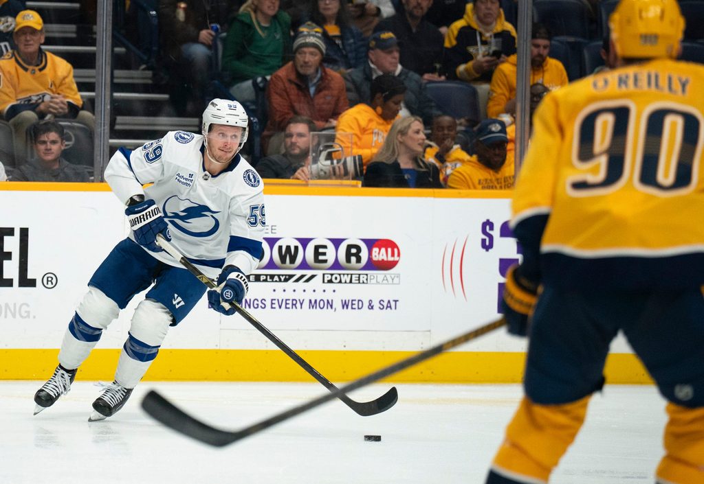 Tampa Bay center Jake Guentzel (59) handles the puck against Nashville center Ryan O'Reilly (90) during their game at Bridgestone Arena in Nashville, Tenn., Tuesday, Oct. 28, 2025.