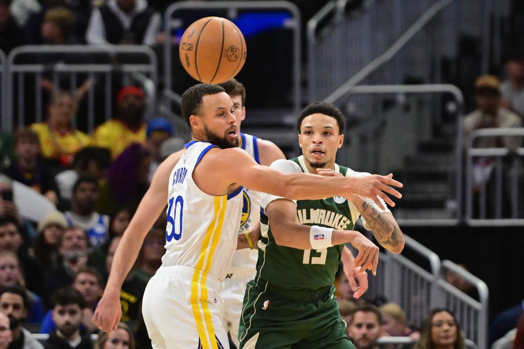 Oct 30, 2025; Milwaukee, Wisconsin, USA; Milwaukee Bucks guard Ryan Rollins (13) passes the ball away from Golden State Warriors guard Stephen Curry (30) in the first quarter at Fiserv Forum. Mandatory Credit: Benny Sieu-Imagn Images
