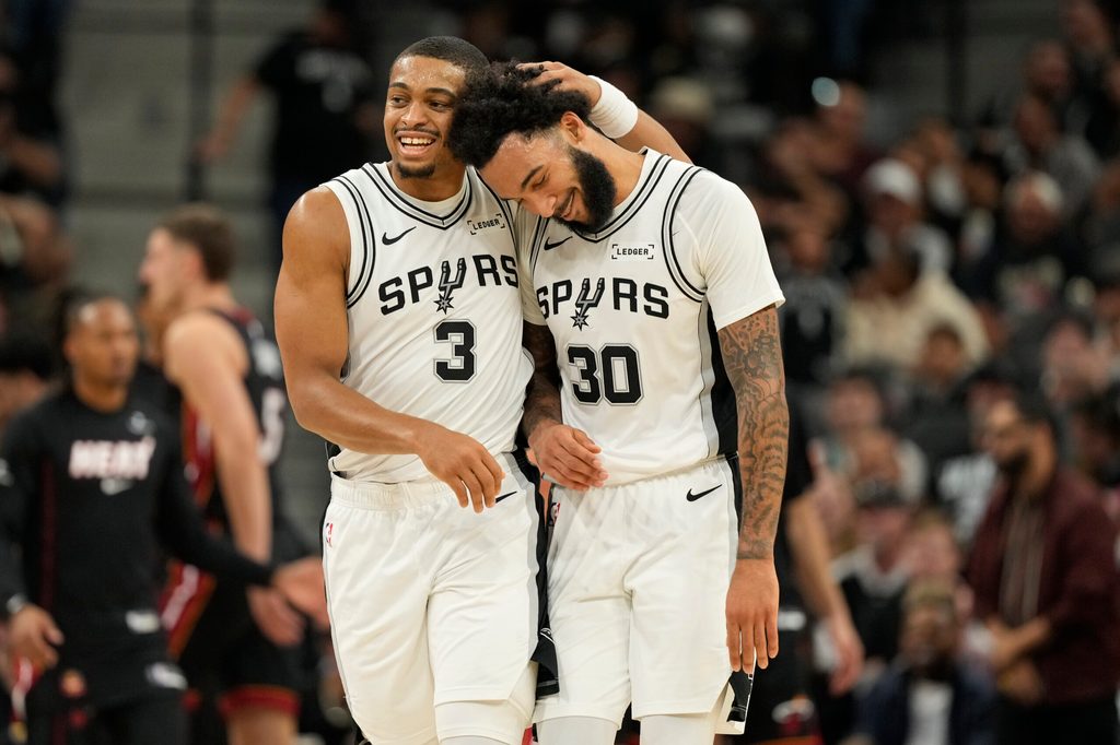 Oct 30, 2025; San Antonio, Texas, USA; San Antonio Spurs forward Keldon Johnson (3) and forward Julian Champagnie (30) react after the first quarter against the Miami Heat at Frost Bank Center. Mandatory Credit: Scott Wachter-Imagn Images