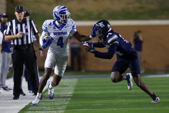 Oct 31, 2025; Houston, Texas, USA; After catching the ball Memphis Tigers wide receiver Cortez Braham Jr. (4) stiff arms Rice Owls cornerback Ephraim Dotson (14) in the second quarter at Rice Stadium. Mandatory Credit: Thomas Shea-Imagn Images
