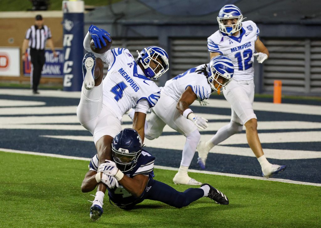 Oct 31, 2025; Houston, Texas, USA; Memphis Tigers wide receiver Cortez Braham Jr. (4) is tackled by Rice Owls safety Marcus Williams (4) in the second half at Rice Stadium. Mandatory Credit: Thomas Shea-Imagn Images