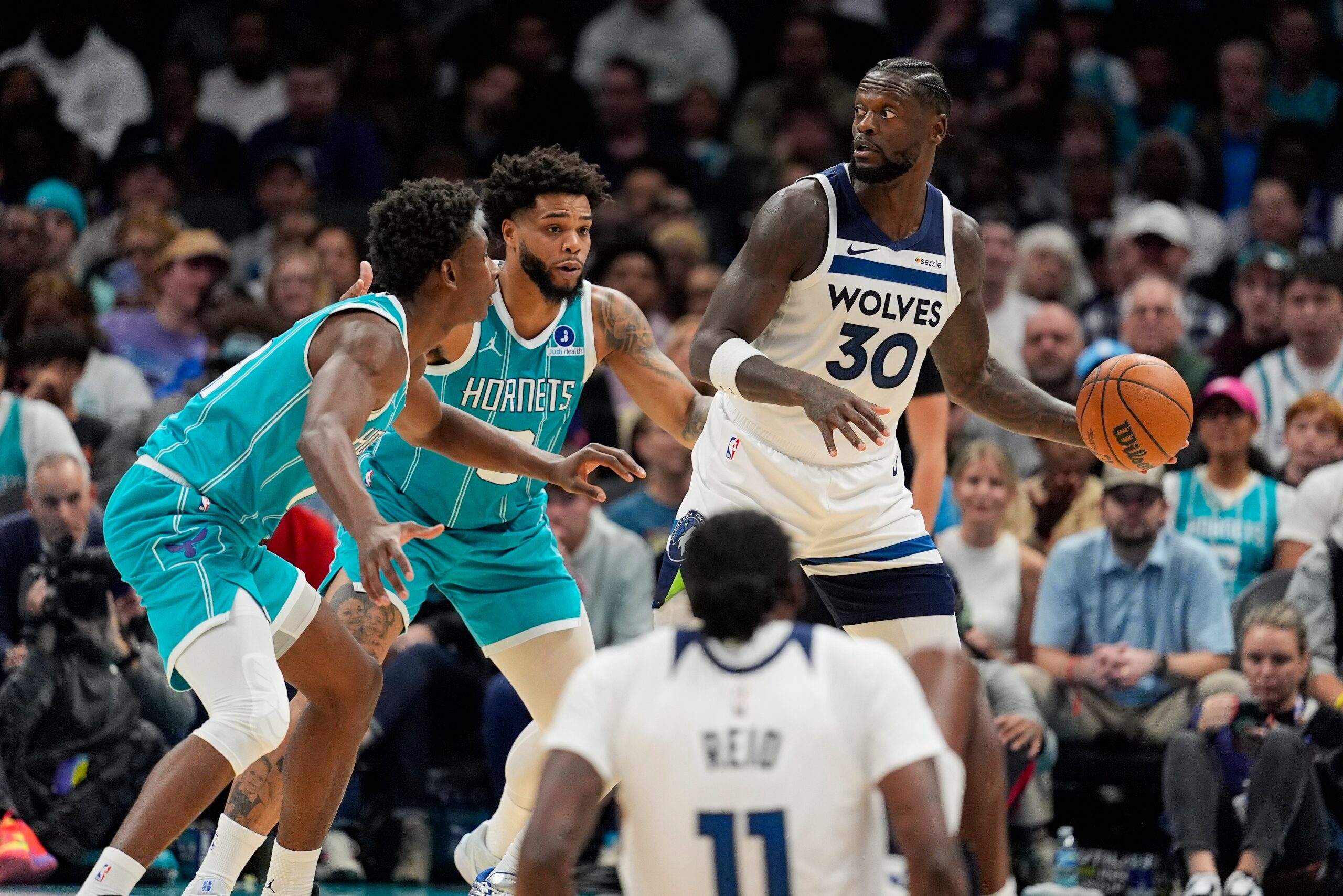 Nov 1, 2025; Charlotte, North Carolina, USA; Minnesota Timberwolves forward Julius Randle (30) looks to pass against Charlotte Hornets forward Miles Bridges (0) and forward Moussa Diabate (14) during the second quarter at Spectrum Center. Mandatory Credit: Jim Dedmon-Imagn Images