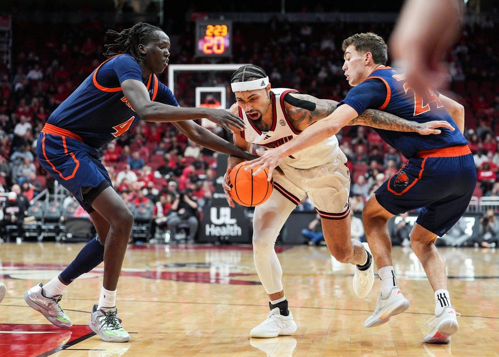 Louisville Cardinals guard J'Vonne Hadley (1) drives under pressure from Bucknell Bison forward Ruot Bijiek (4) and Bucknell Bison guard Achile Spadone (24) during an exhibition game at the KFC Yum! Center in Louisville, Kentucky TuesdayOctober 28, 2025.