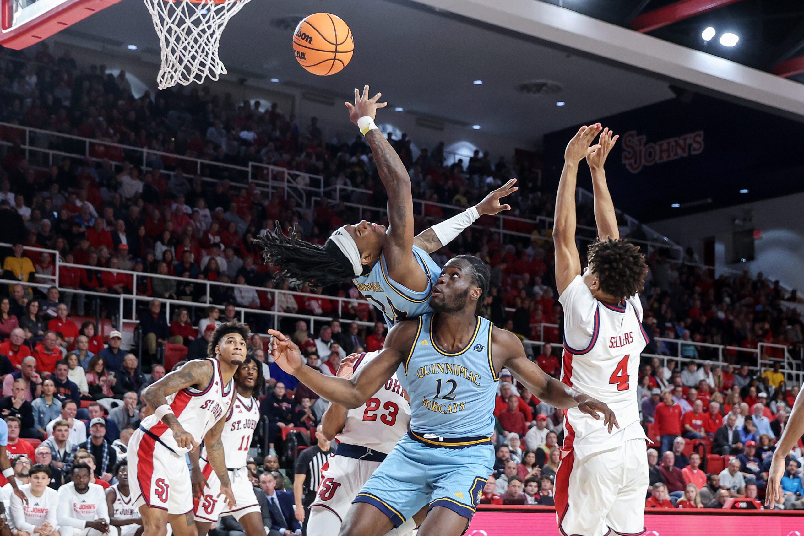 Nov 3, 2025; Queens, New York, USA;  Quinnipiac Bobcats guard Jaden Zimmerman (24) collides with forward Spence Wewe (12) in the first half against the St. John's Red Storm at Carnesecca Arena. Mandatory Credit: Wendell Cruz-Imagn Images
