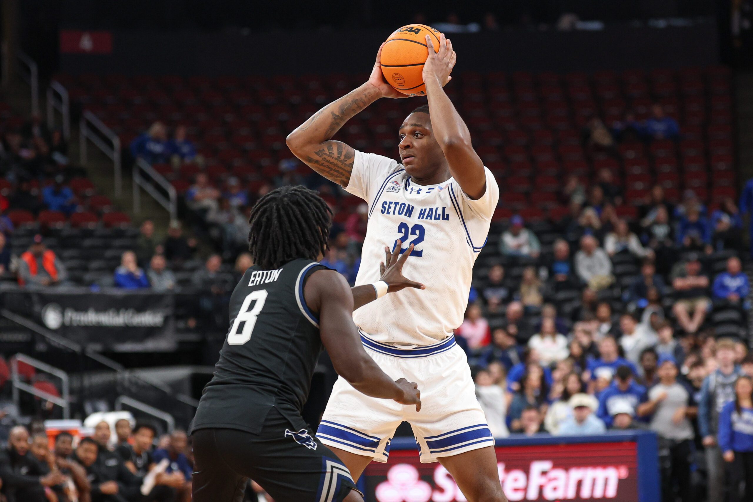 Nov 3, 2025; Newark, New Jersey, USA; Seton Hall Pirates guard Elijah Fisher (22) is guarded by Saint Peter's Peacocks guard Bryce Eaton (8) during the second half at Prudential Center. Mandatory Credit: Vincent Carchietta-Imagn Images