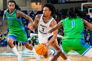 New College of Florida Mighty Banyans guard Adrian Moore (3) drives to the basket as Florida Gulf Coast Eagles guards Jordan Ellerbee (7) and Rahmir Barno (1) cover him during the first half of the season opener at Alico Arena in Fort Myers, Fla., on Monday, Nov. 3, 2025.