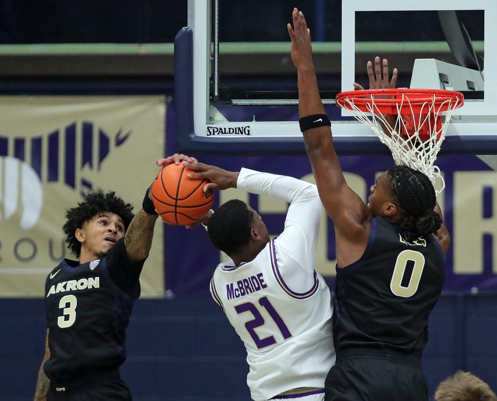 Akron Zips guard Sharron Young (3) and forward Amani Lyles (0) work to block James Madison Dukes forward Justin McBride (21) during the first half of an NCAA college basketball game at James A. Rhodes Arena, Nov. 3, 2025, in Akron, Ohio