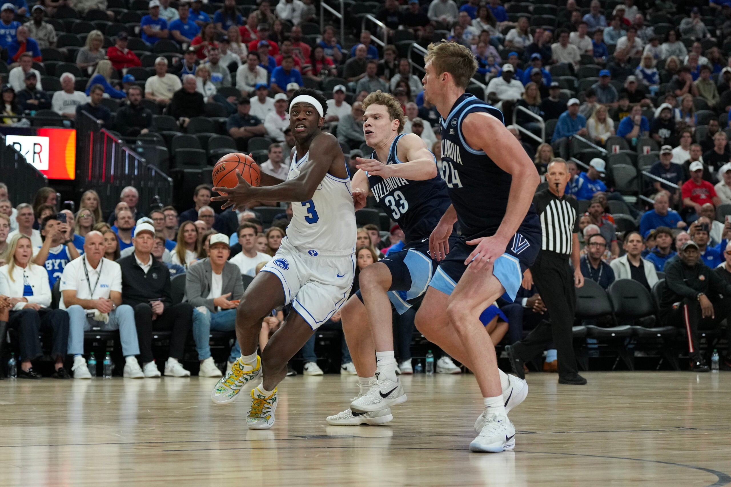 Nov 3, 2025; Las Vegas, Nevada, USA; BYU Cougars forward AJ Dybantsa (3) drives past Villanova Wildcats forward Matt Hodge (33) and forward Duke Brennan (24) during the first half of the Hall of Fame Series game at T-Mobile Arena. Mandatory Credit: Candice Ward-Imagn Images
