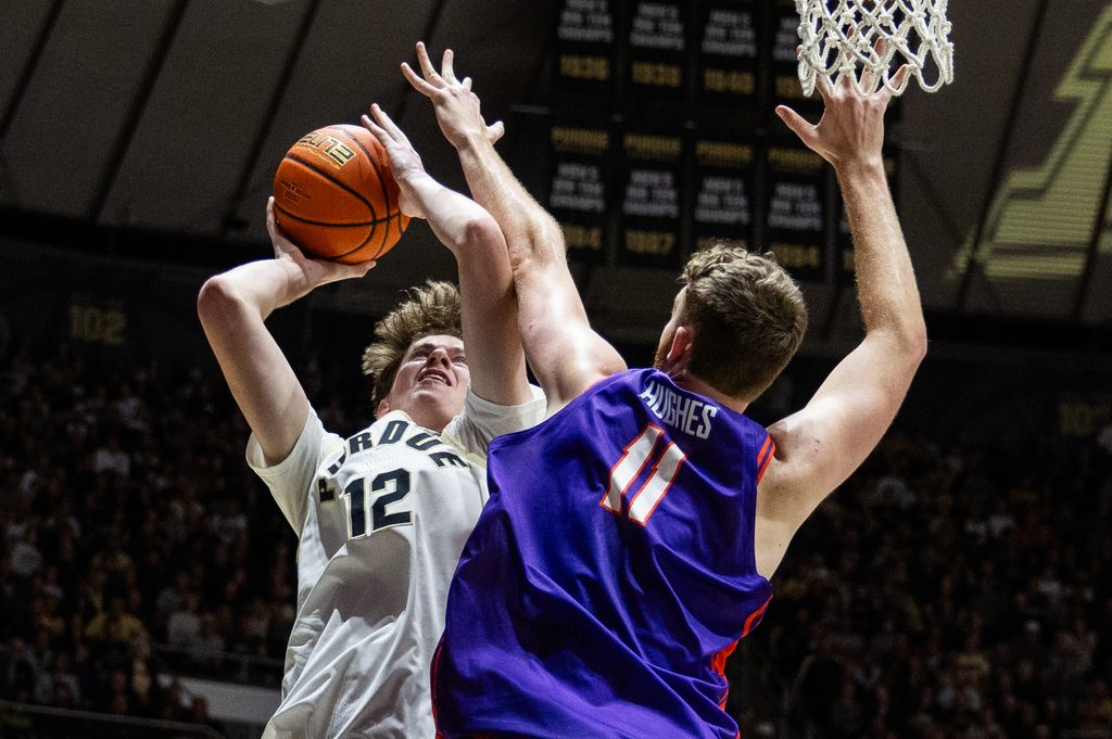 Nov 4, 2025; West Lafayette, Indiana, USA; Purdue Boilermakers center Daniel Jacobsen (12) shoots the ball while Evansville Purple Aces forward Joshua Hughes (11) defends in the second half at Mackey Arena. Mandatory Credit: Trevor Ruszkowski-Imagn Images