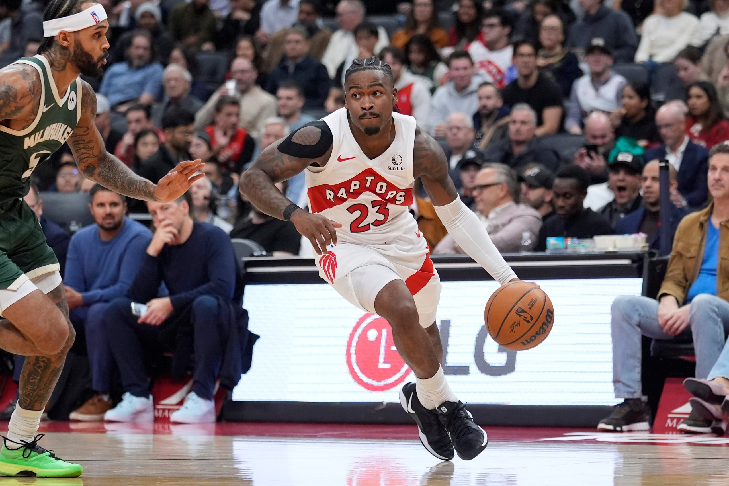 Nov 4, 2025; Toronto, Ontario, CAN; Toronto Raptors guard Jamal Shead (23) drives tot he net against Milwaukee Bucks guard Gary Trent Jr. (5) during the second half at Scotiabank Arena. Mandatory Credit: John E. Sokolowski-Imagn Images