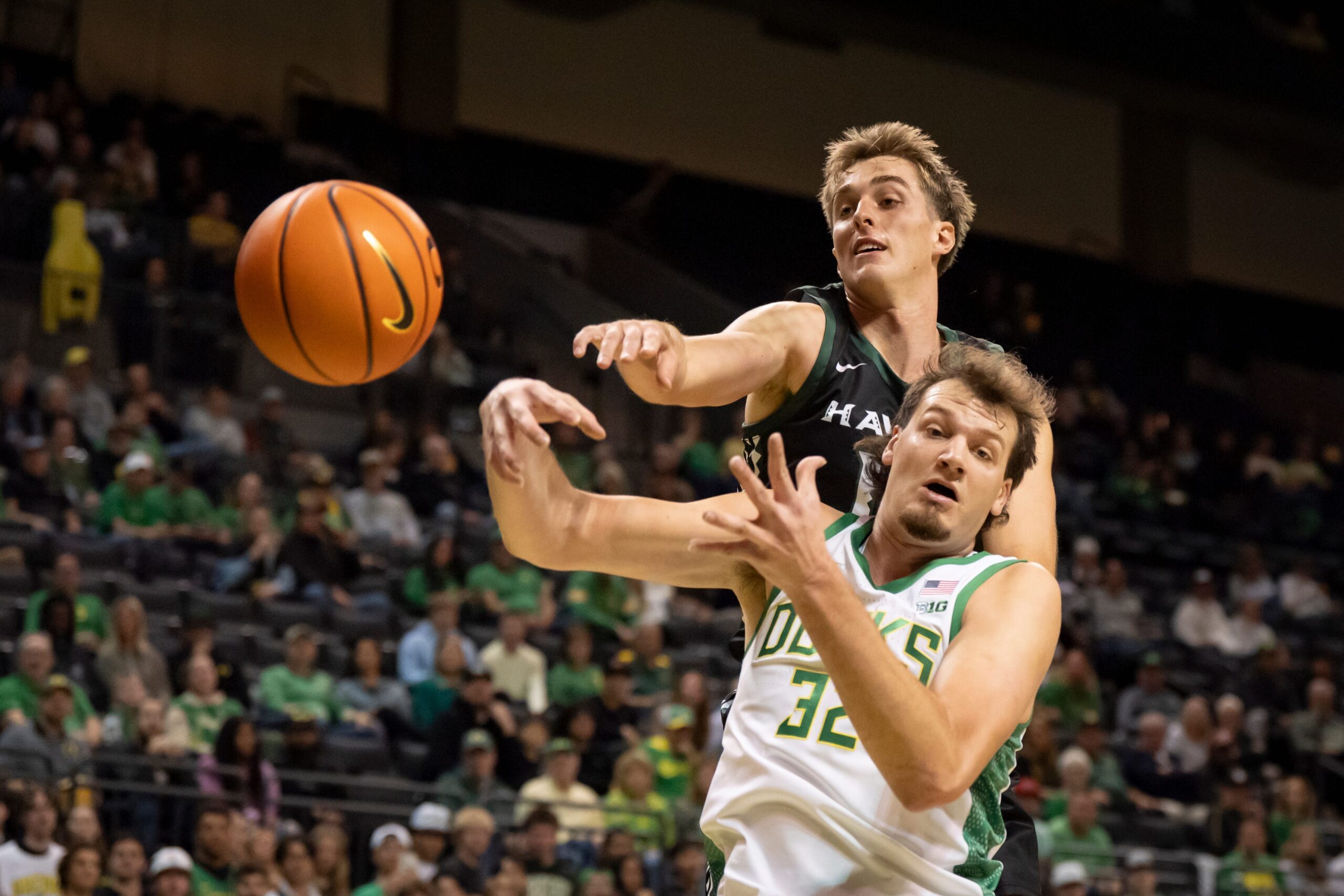 Hawaii forward Harry Rouhliadeff, left, and Oregon center Nate Bittle go after a rebound as the Oregon Ducks host the Hawaii Rainbow Warriors on Nov. 4, 2025, at Matthew Knight Arena in Eugene, Oregon.