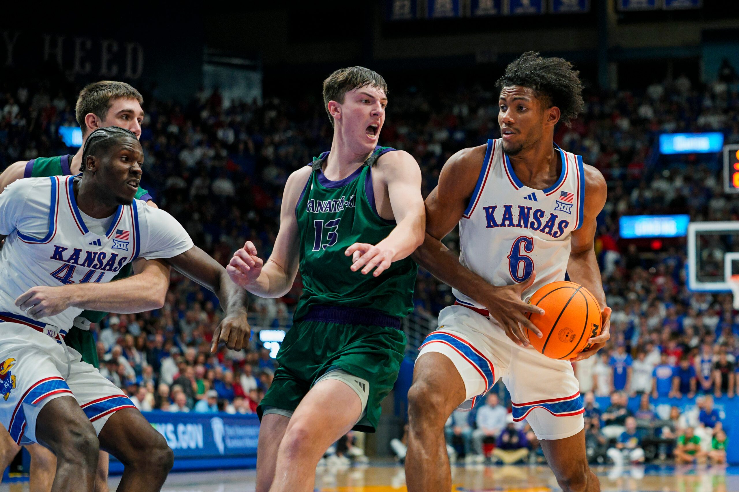 Nov 3, 2025; Lawrence, Kansas, USA; Kansas Jayhawks forward Samis Calderon (6) drives against Green Bay Phoenix forward Marcus Hall (13) during the second half at Allen Fieldhouse. Mandatory Credit: Jay Biggerstaff-Imagn Images
