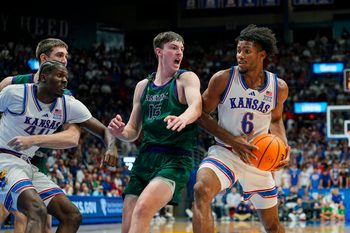 Nov 3, 2025; Lawrence, Kansas, USA; Kansas Jayhawks forward Samis Calderon (6) drives against Green Bay Phoenix forward Marcus Hall (13) during the second half at Allen Fieldhouse. Mandatory Credit: Jay Biggerstaff-Imagn Images